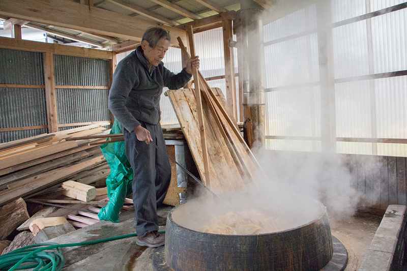 大きな釜で、楮の白皮を煮熟する